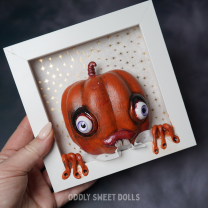  framed white frame with [umpkin big eyes and teeth