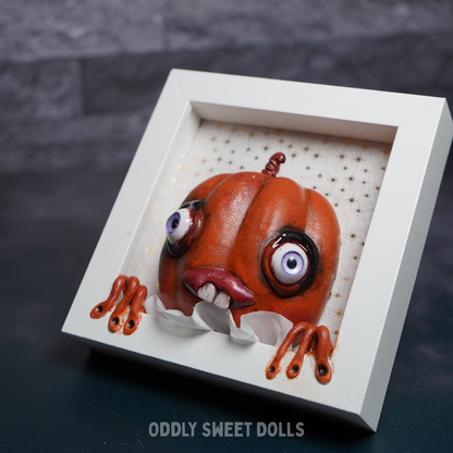 framed white frame with [umpkin big eyes and teeth