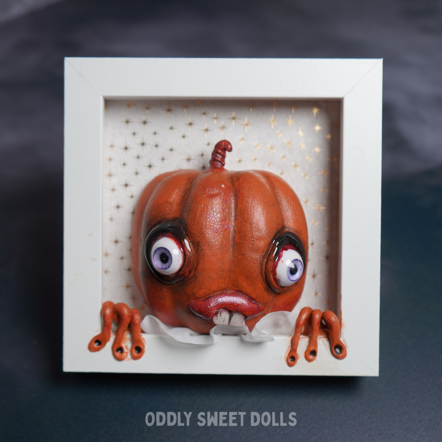 framed white frame with [umpkin big eyes and teeth