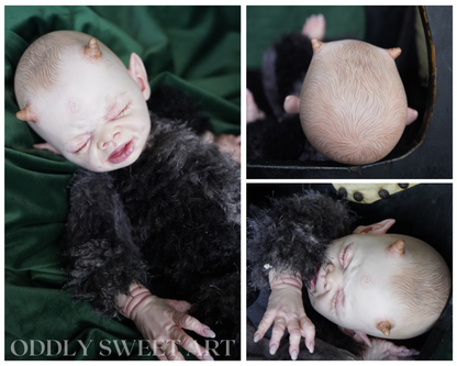 reborn baby doll fawn sitting on a black victorian rocking chair