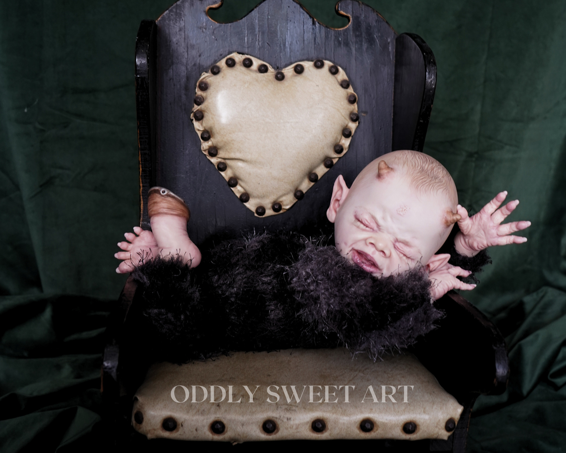 reborn baby doll fawn sitting on a black vitorican rocking chair