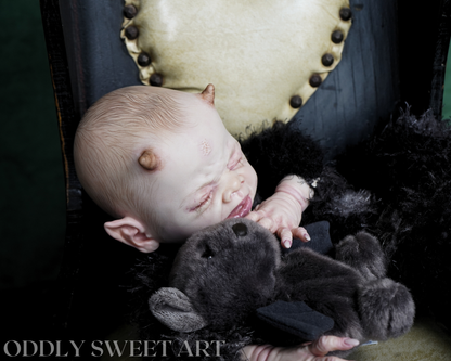 reborn baby doll fawn sitting on a black victorian rocking chair