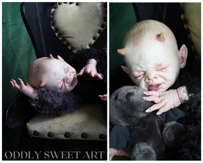 reborn baby doll fawn sitting on a black victorian rocking chair