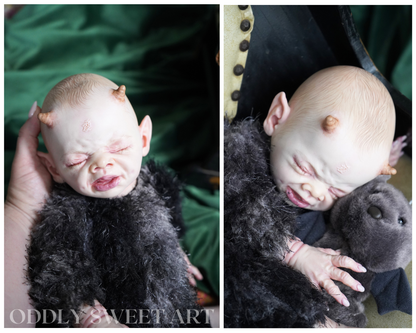 reborn baby doll fawn sitting on a black victorian rocking chair