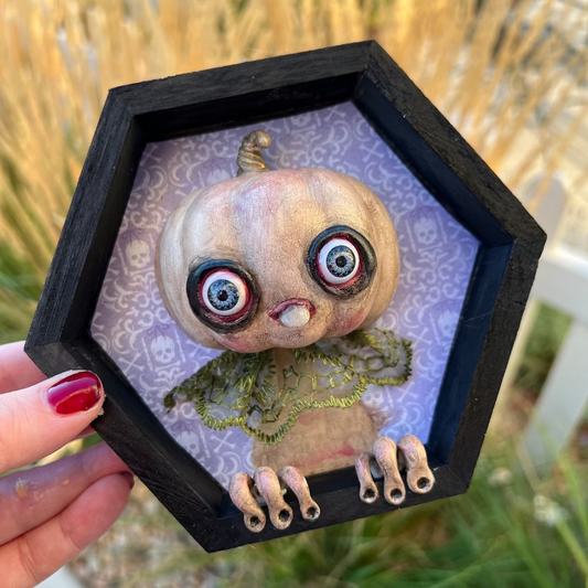 Hexagonal black frame with a怪异的娃娃在草地上
