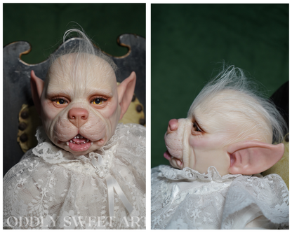 A split-view product photo of a realistic doll or character figure with pale skin, pointed ears, white hair, and a white lace dress, shown from the front and side against a dark green backdrop. A watermark reading 'ODDISSWEETART' appears at the bottom left.