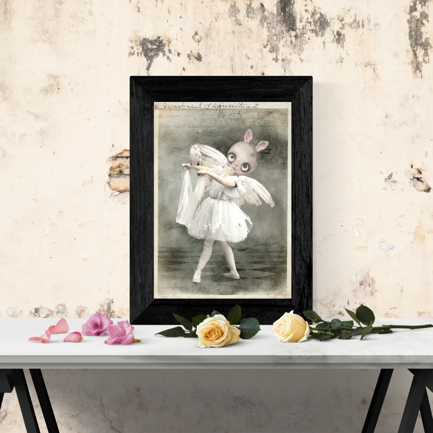 white background post card art print bunny ballerina holding a white owl framed in a black frame on table top