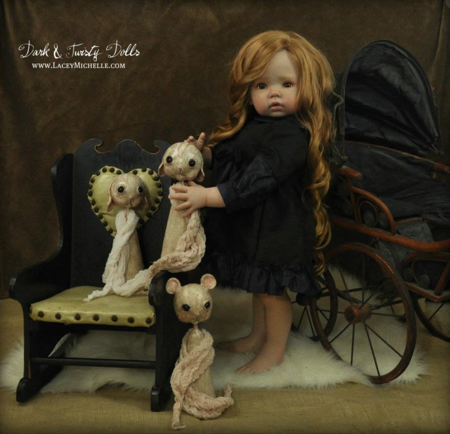 A posed doll scene with a large doll in a black dress holding a pale stitched mouse, next to a small doll on a chair and another stitched mouse on the floor. A vintage pram is visible in the background against a brown backdrop.